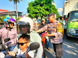 Bhabinkamtibmas Rawa Lumbu Gelar Aksi Patriotik, Bagikan Bendera Merah Putih di Lampu Merah Kemang Pratama